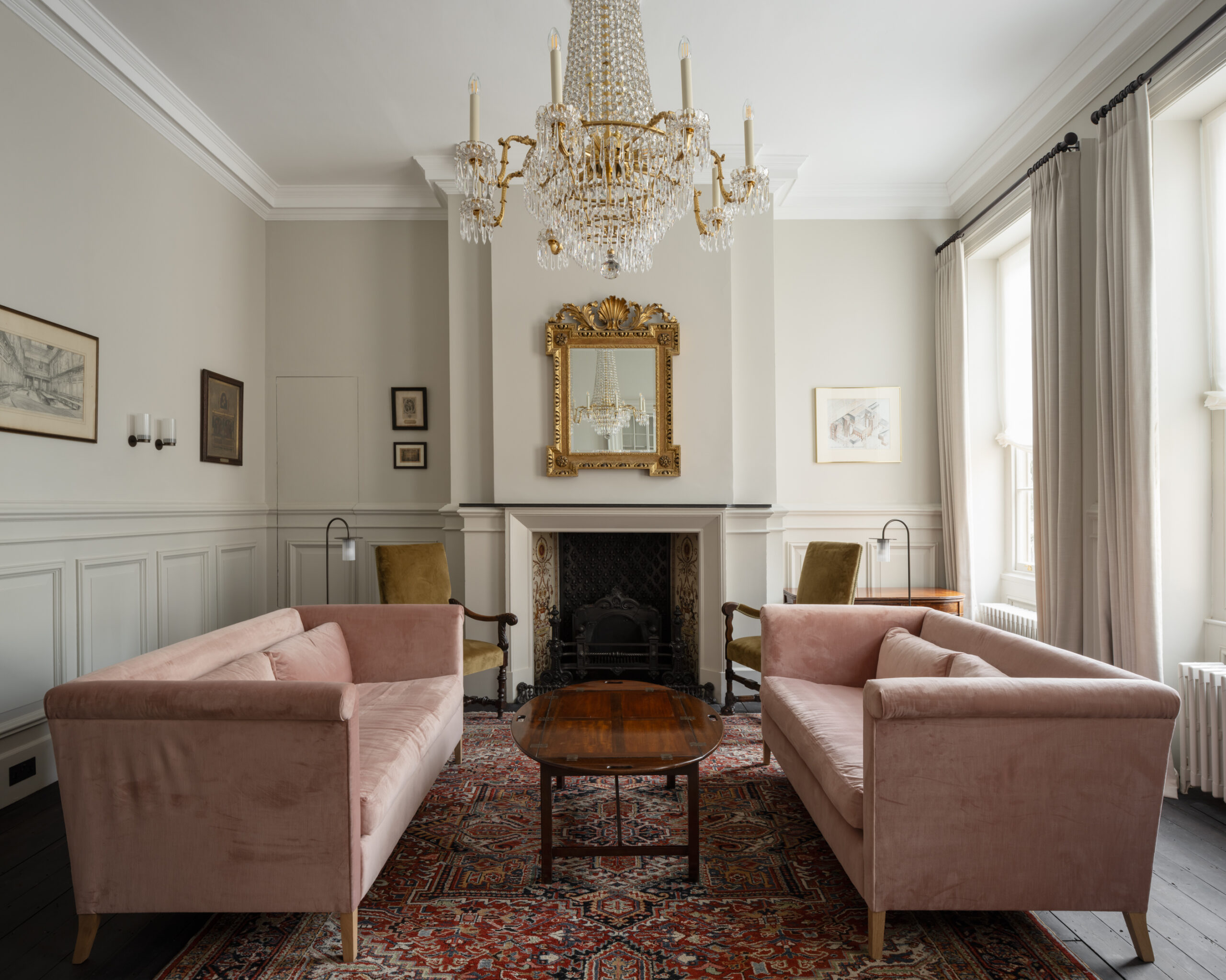 Formerly a library housing the Company’s ancient and priceless book collection, the airy, light-filled Members’ Drawing Room enjoys views onto the new College Street entrance. The room was substantially redecorated. Timber flooring was exposed and stained dark, plasterwork and timber mouldings was restored and panelling and period built in bookcases unified in neutral paint tones. Shuttered windows were dressed with new linen curtains and the existing chandelier was restrung and fitted with LED lamps. Several existing antique pieces were restored to the room, while new, Norfolk-made, rose-coloured sofas were commissioned for the centre-floor. A pair of 18th century elbow chairs were reupholstered in new, olive velvet.